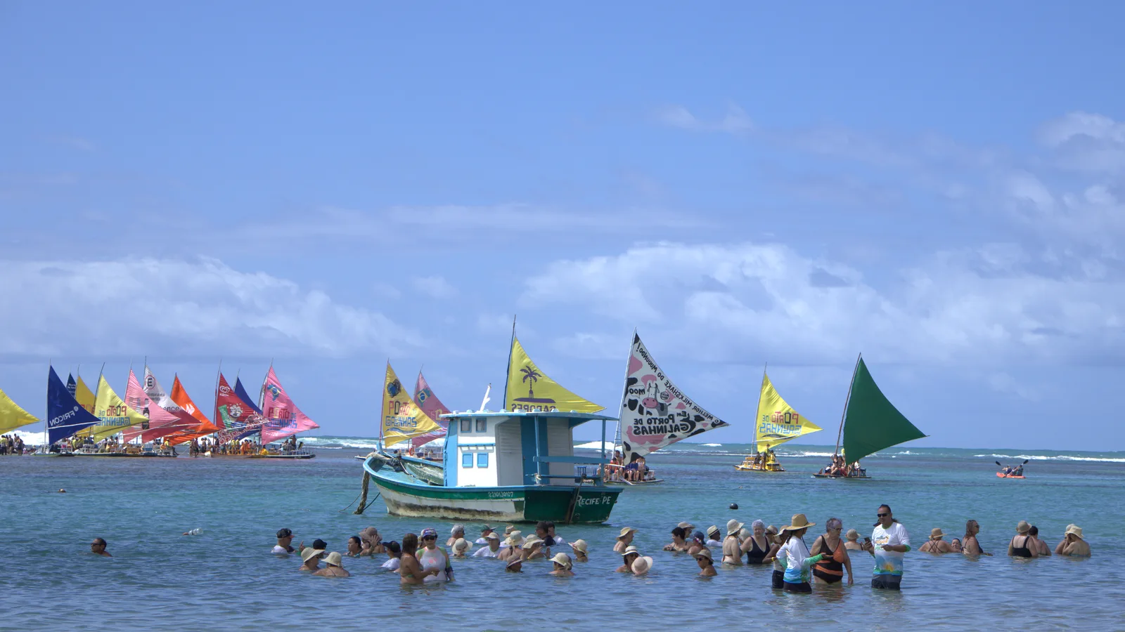 Jangadas e visitantes vivendo Porto de Galinhas